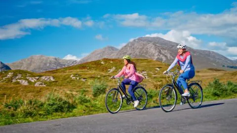Guests enjoy cycling on scenic mountain paths under clear skies, highlighting hotel's outdoor adventure amenities.