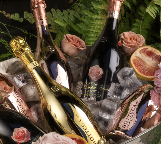 Elegant champagne bottles in an ice bucket adorned with roses and greenery, evoking luxury and celebration.