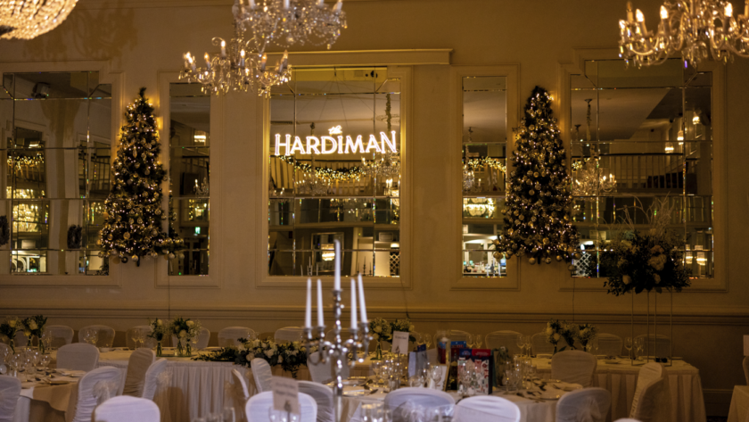 Elegant hotel dining room with chandeliers, festive décor, and candlelit tables set for a cosy, refined experience.