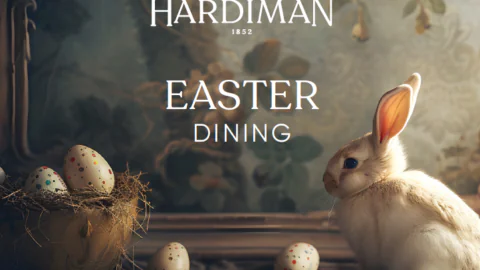 Charming Easter scene with a fluffy rabbit and colourful eggs, inviting guests to enjoy special dining at The Hardiman.