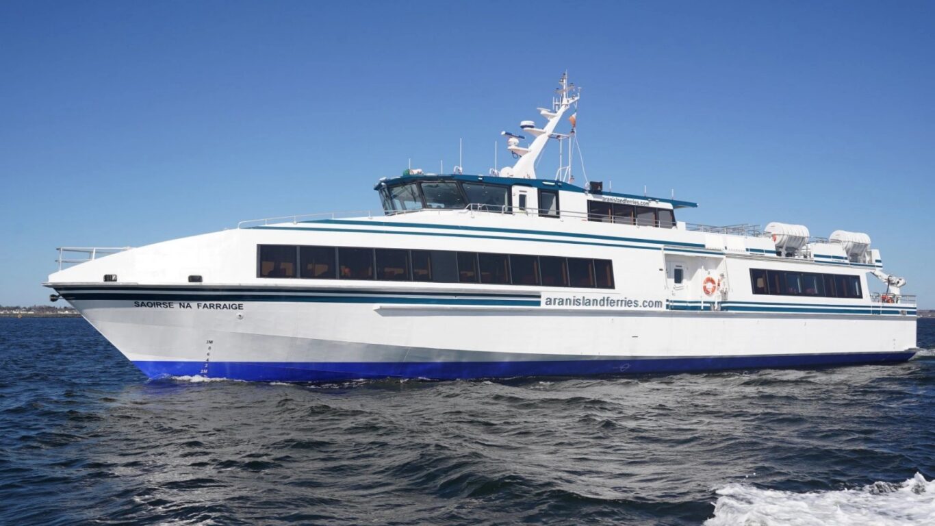 Modern ferry cruising on calm blue sea under clear sky, offering scenic coastal views and a relaxing maritime journey.