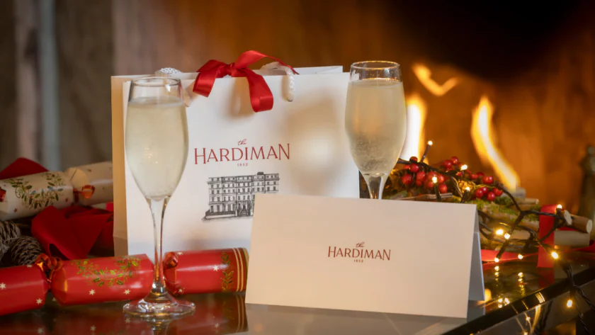 Two glasses of champagne, a gift bag, and an envelope labeled