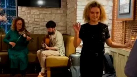 A woman standing in front of a group of people.