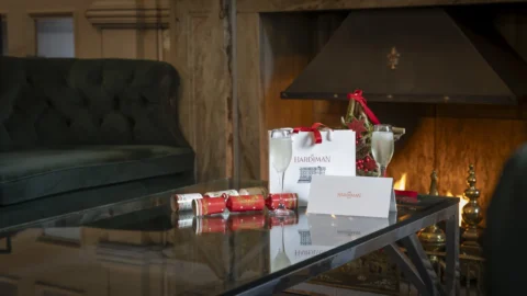 Cosy hotel lounge with a fireplace, festive decor, and champagne, perfect for a relaxing stay.