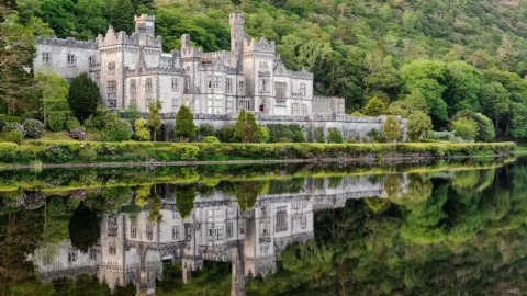 Stunning lakeside castle hotel amidst lush greenery, offering a serene and historic getaway experience.